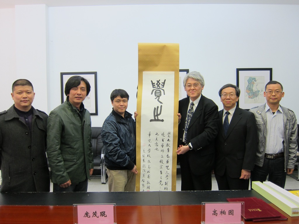 高柏園校長(右三)一行赴四川美術學院，高校長致贈書法卷軸給四川美術學院龐茂琨校長(左三)，右二為華梵大學簡江儒主任秘書、右一為四川宜賓學院黨政辦夏新強主任、左二為國際交流與合作處曾岳處長及吳建軍老師