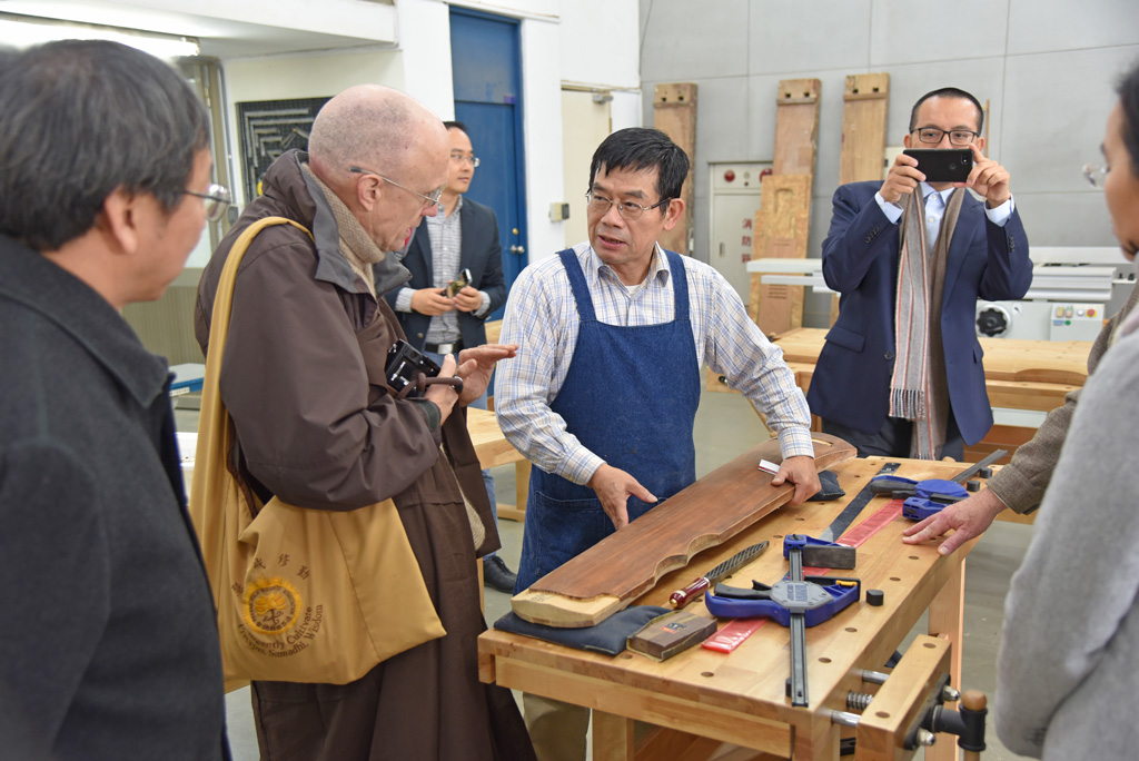 法界佛教總會董事長恆實法師參觀校級工場古琴製作，由斲琴藝術家廖寶林老師解說。